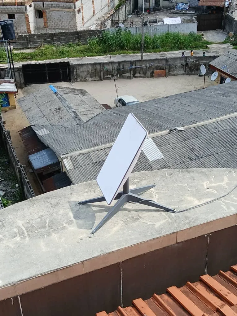 Starlink dish on its base on a flat rooftop parapet