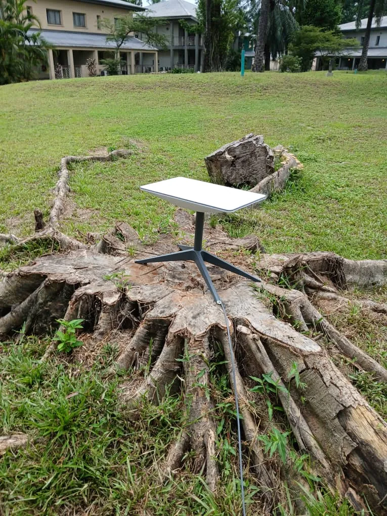 Starlink dish on open ground in a large lawn compound
