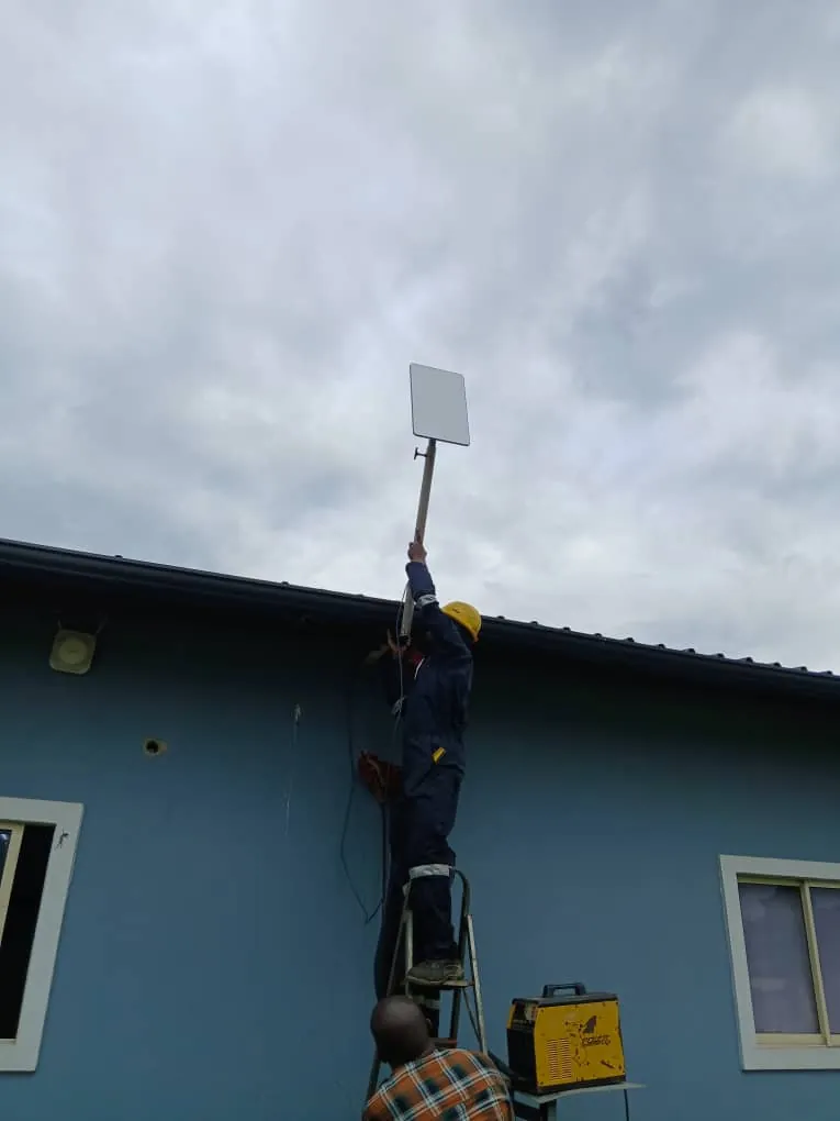 Installer raising the Starlink dish on the welded pole