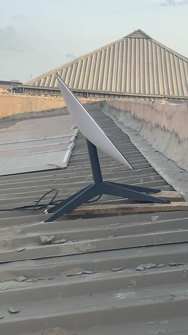Starlink dish on its base on a corrugated metal roof