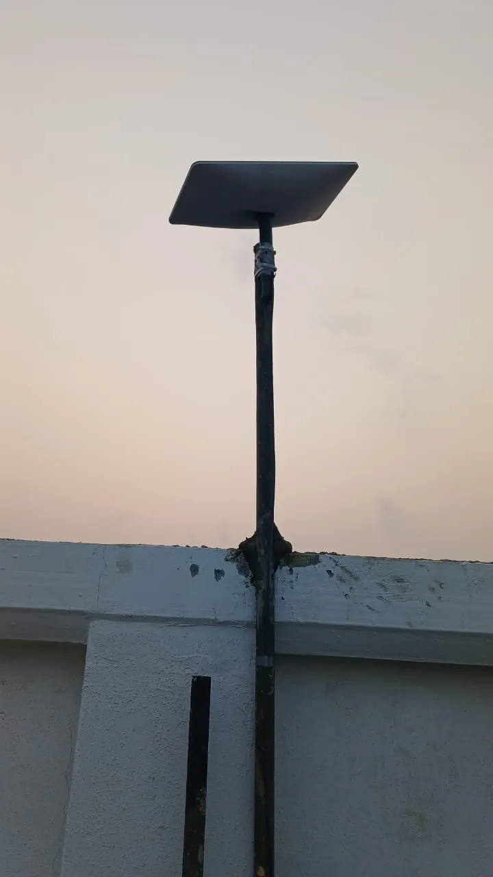 Starlink dish on a steel pole set into the roof parapet of a new commercial building