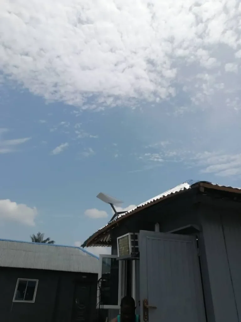 Starlink dish on a bracket at the roof edge of a site cabin