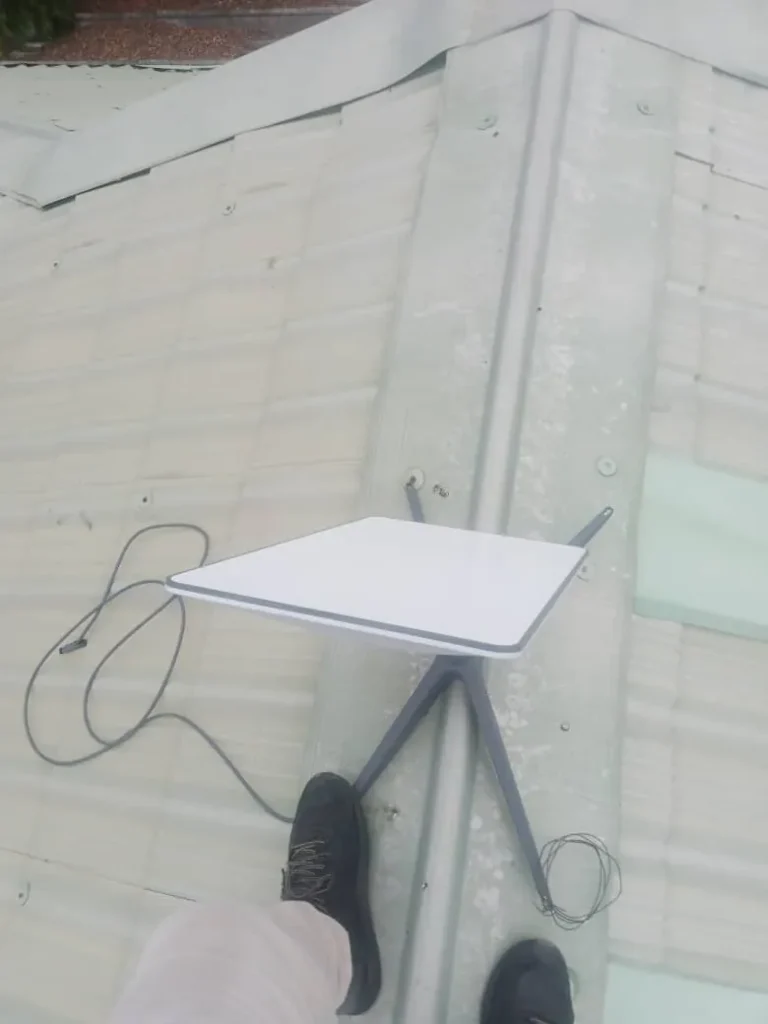ZuraLink installer fixing the Starlink base on the roof ridge