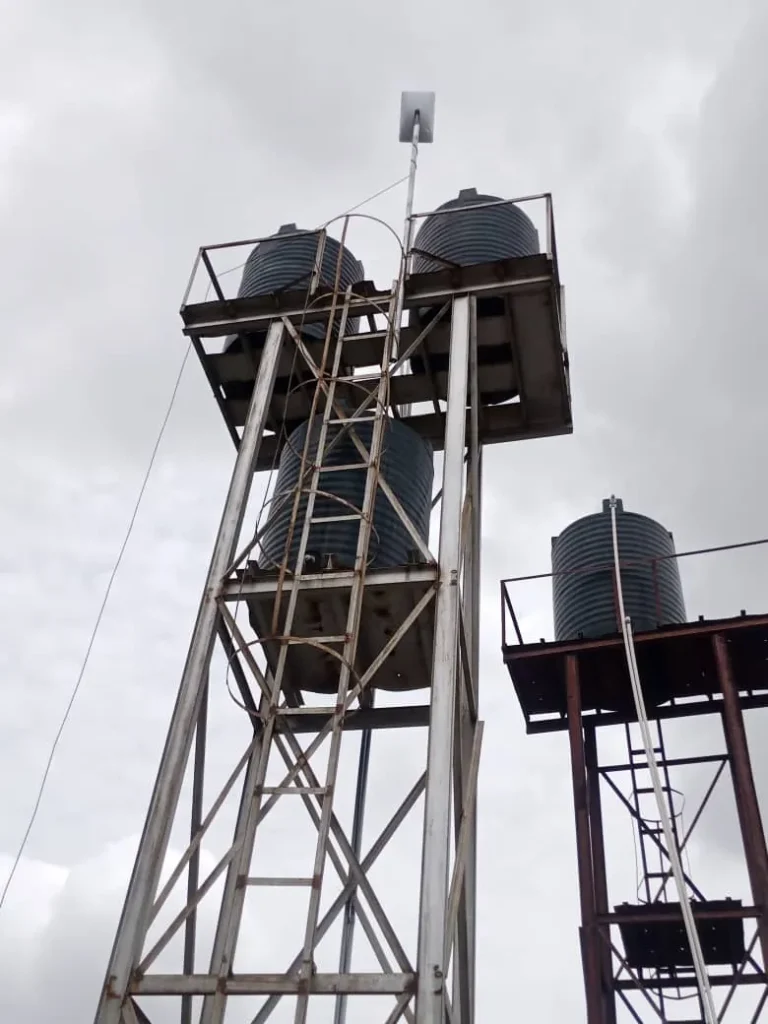 Starlink dish on an extension pole above a steel water-tank tower