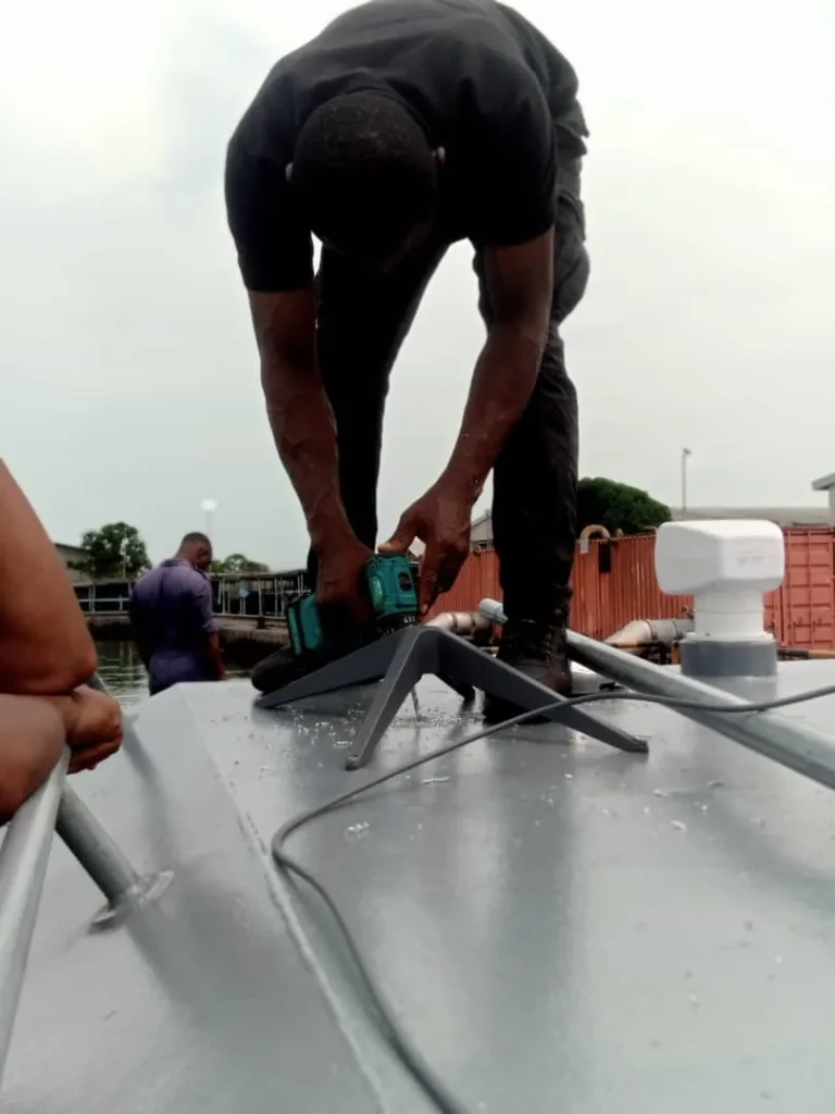 ZuraLink installer bolting the Starlink base to the boat's cabin roof
